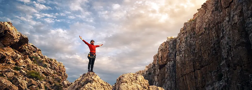 Climber on rocky summit in Morocco at sunset