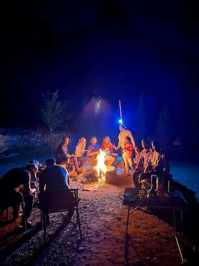 The climbers sit by the fire at night at the Gagou site