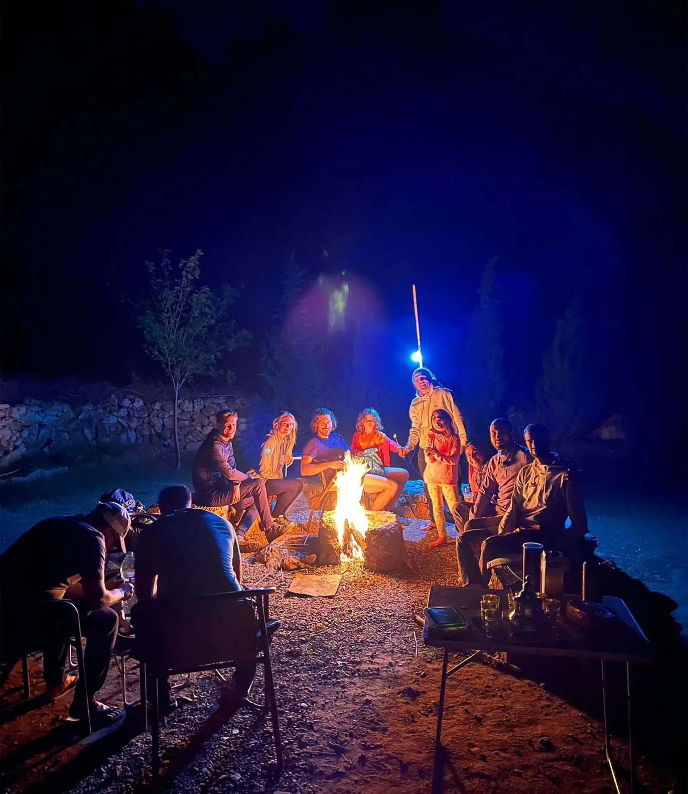 The climbers sit by the fire at night at the Gagou site
