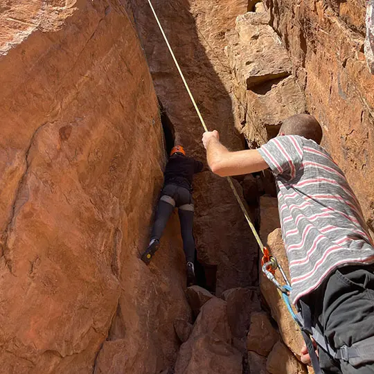 Rock climbing in Morocco with a climber tackling a crack route while secured by a belayer